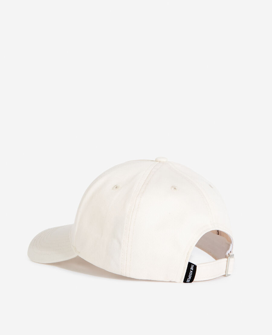 white cotton cap with embroidered “what is”