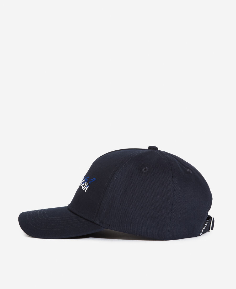 navy blue cotton cap with embroidered “what is”