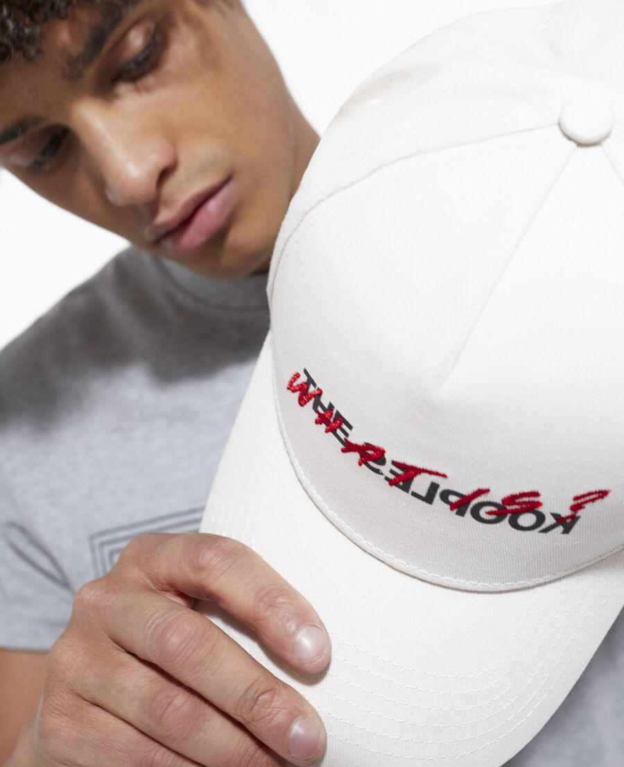 white cotton cap with embroidered “what is”