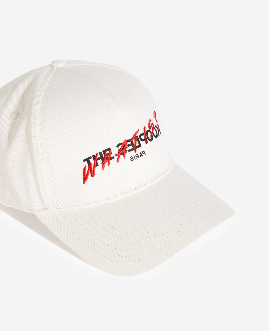 white cotton cap with embroidered “what is”