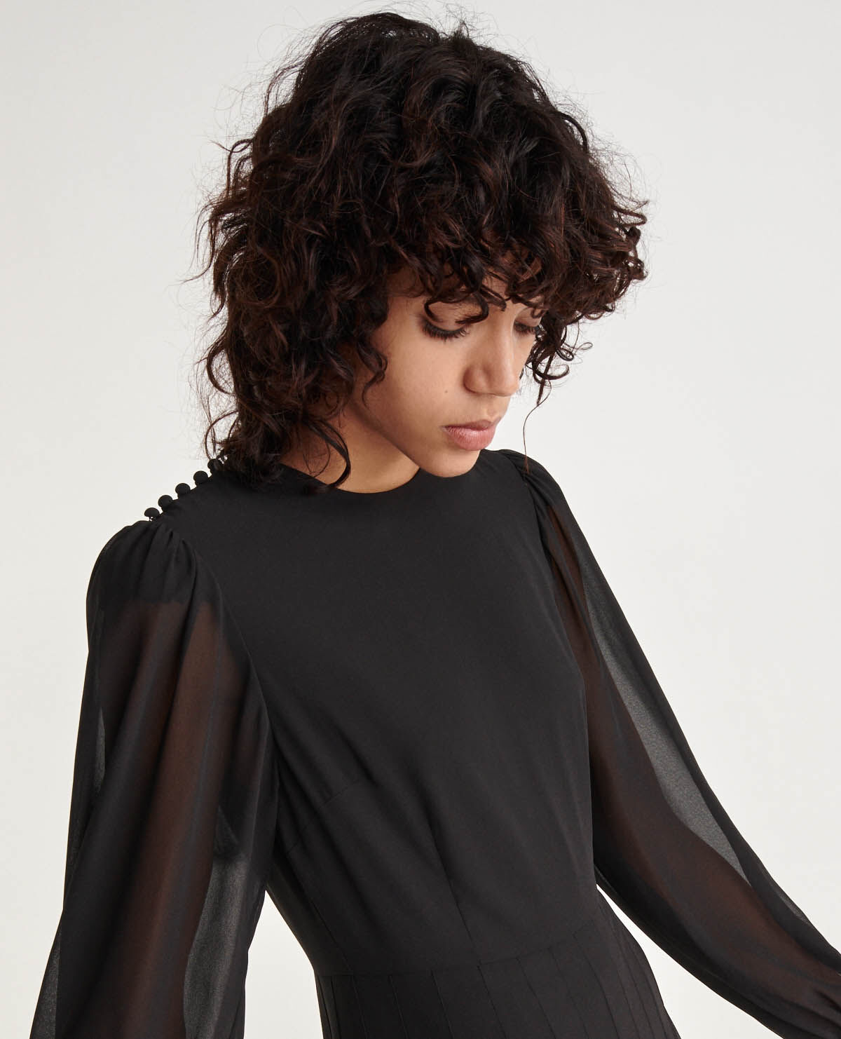 Robe noire plissée manche longue store